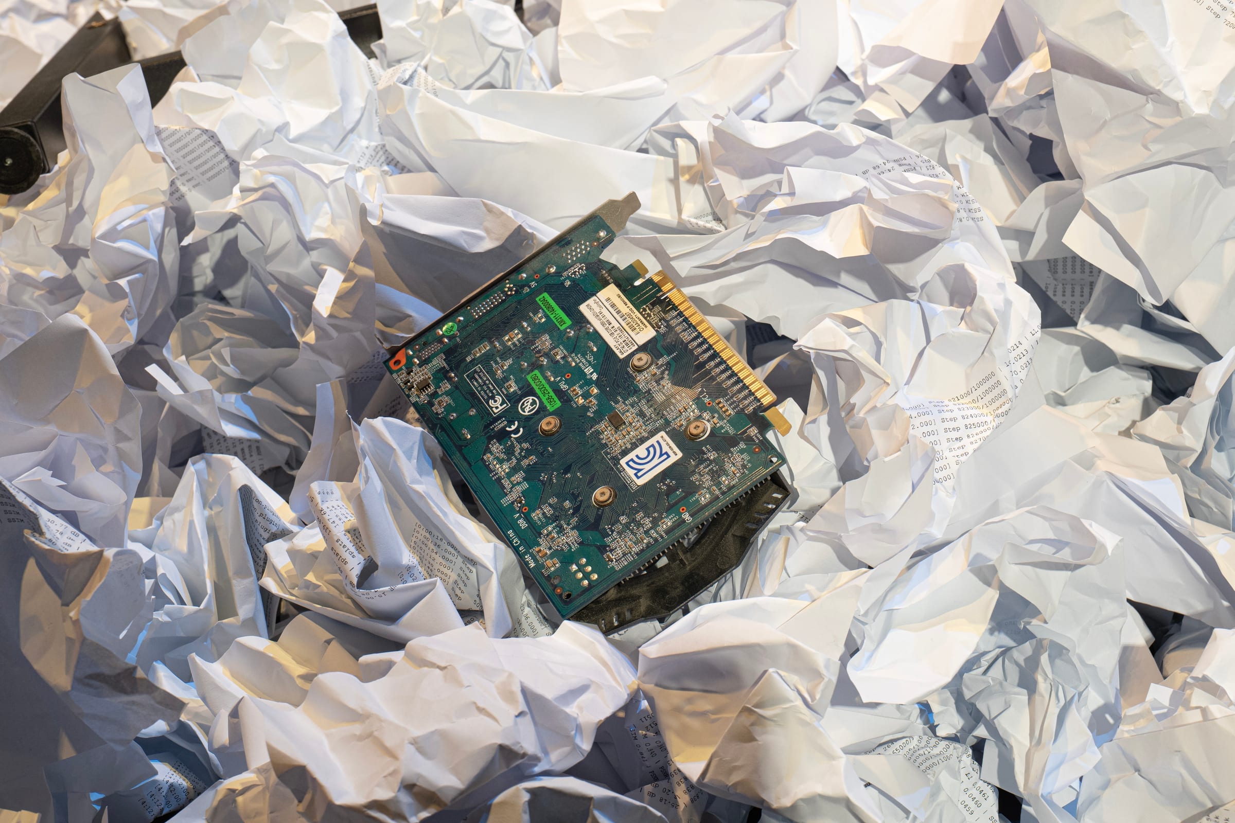 Graphics card resting on crumpled printouts